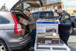 Bryson Fico, left, unloaded box of books from his car with the help of Custody Officer Jason Morton as a donation to the Marysville Jail on Saturday, April 5, 2025 in Marysville, Washington. (Olivia Vanni / The Herald)