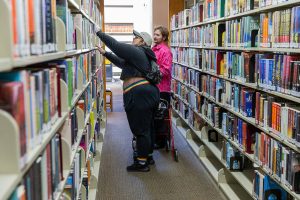 Ash Roberts, left, and Wryly T McCutchen, right, browse for book at the Everett Public Library on Thursday, April 3, 2025 in Everett, Washington. (Olivia Vanni / The Herald)