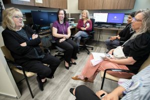 Providence Behavioral Health Urgent Care employees chat after a short training presentation on Wednesday, Aug. 21, 2024 in Everett, Washington. (Olivia Vanni / The Herald)