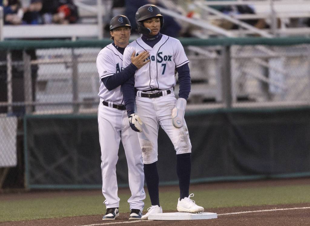 Everett AquaSox outfielder Tai Peete talks with AquaSox manger Zach Vincej on third base during the Opening Day game against the Hillsboro Hops on Tuesday, April 8, 2025 in Everett, Washington. (Olivia Vanni / The Herald)