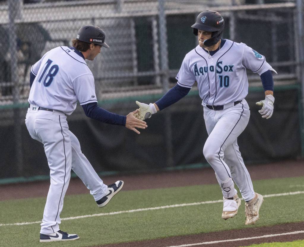 Everett AquaSox catcher Josh Caron high-fives AquaSox manger Zach Vincej after hitting a home run during the Opening Day game against the Hillsboro Hops on Tuesday, April 8, 2025 in Everett, Washington. (Olivia Vanni / The Herald)