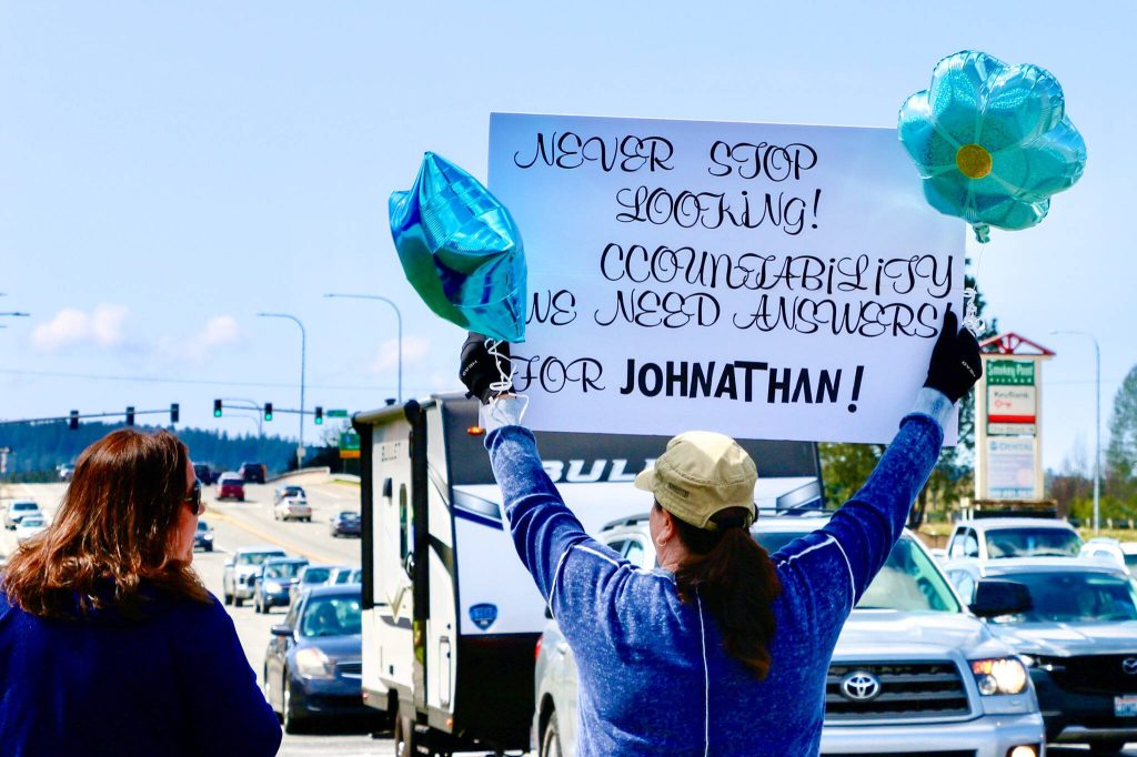 At the intersection of Smokey Point Boulevard and 172nd St. NE, cars honk as protesters hold signs reading Never stop looking and display blue balloons for Autism Awareness Month during a call to action Saturday, April 12, 2025, in Arlington. (Aspen Anderson / The Herald)