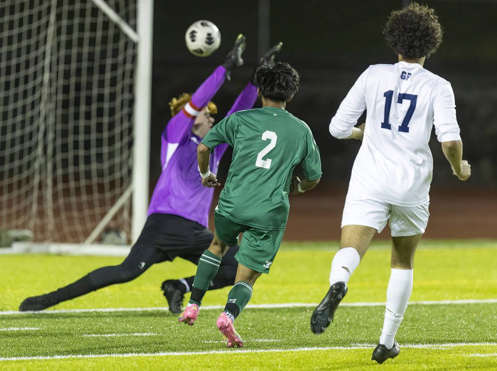 Jacksons Isaiah Natividad shot clears the outstretched hands of Glacier Peaks Aiden Larsen to score during the game on Tuesday, April 15, 2025 in Everett, Washington. (Olivia Vanni / The Herald)