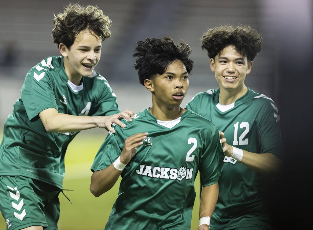 Jacksons Isaiah Natividad is congratulated by his teammates after scoring during the game against Glacier Peak on Tuesday, April 15, 2025 in Everett, Washington. (Olivia Vanni / The Herald)
