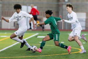 Jackson’s Isaiah Natividad splits Glacier Peak’s defenders as he takes the ball toward the goal during the game on Tuesday, April 15, 2025 in Everett, Washington. (Olivia Vanni / The Herald)
