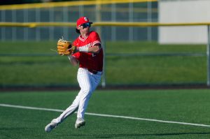 Stanwood outfielder Luke Brennan picks up the ball and gets it back to the infield during a playoff loss to Kentlake on Tuesday, May 14, 2024, at Kent Meridian High School in Kent, Washington. (Ryan Berry / The Herald)