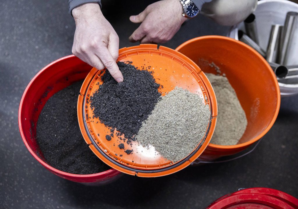 President and Chief Technology Officer of EcoRemedy David Mooney shows two different products they are able to create from the gasification process at the Edmonds Wastewater Treatment Plant on Thursday, April 17, 2025 in Edmonds, Washington. (Olivia Vanni / The Herald)
