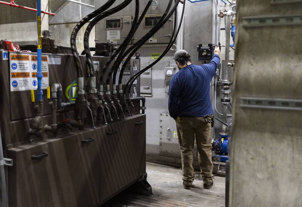 An EcoRemedy employee checks on one of the scrubbing machines at the Edmonds Wastewater Treatment Plant on Thursday, April 17, 2025 in Edmonds, Washington. (Olivia Vanni / The Herald)