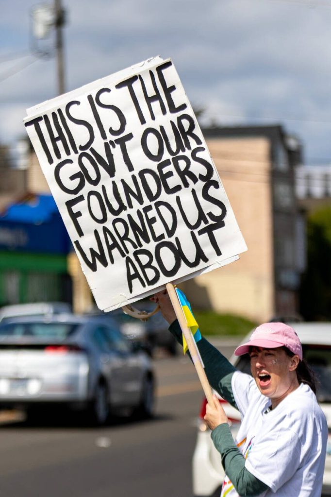 Protesters line Broadway on Saturday, April 19, 2025, in Everett, Washington. (Aaron Kennedy / The Herald)