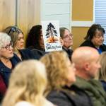 A person holds a sign referencing the recent demolition of a 100-year-old California coast redwood during a city council meeting on Monday, April 21, 2025 in Edmonds, Washington. (Olivia Vanni / The Herald)