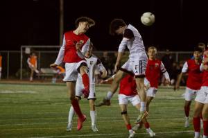Snohomish junior Paul Joplin (left) heads the ball past a jumping Monroe defender in the Panthers' 4-1 loss at Veterans Memorial Stadium in Snohomish, Washington on April 4, 2025. (Joe Pohoryles / The Herald)