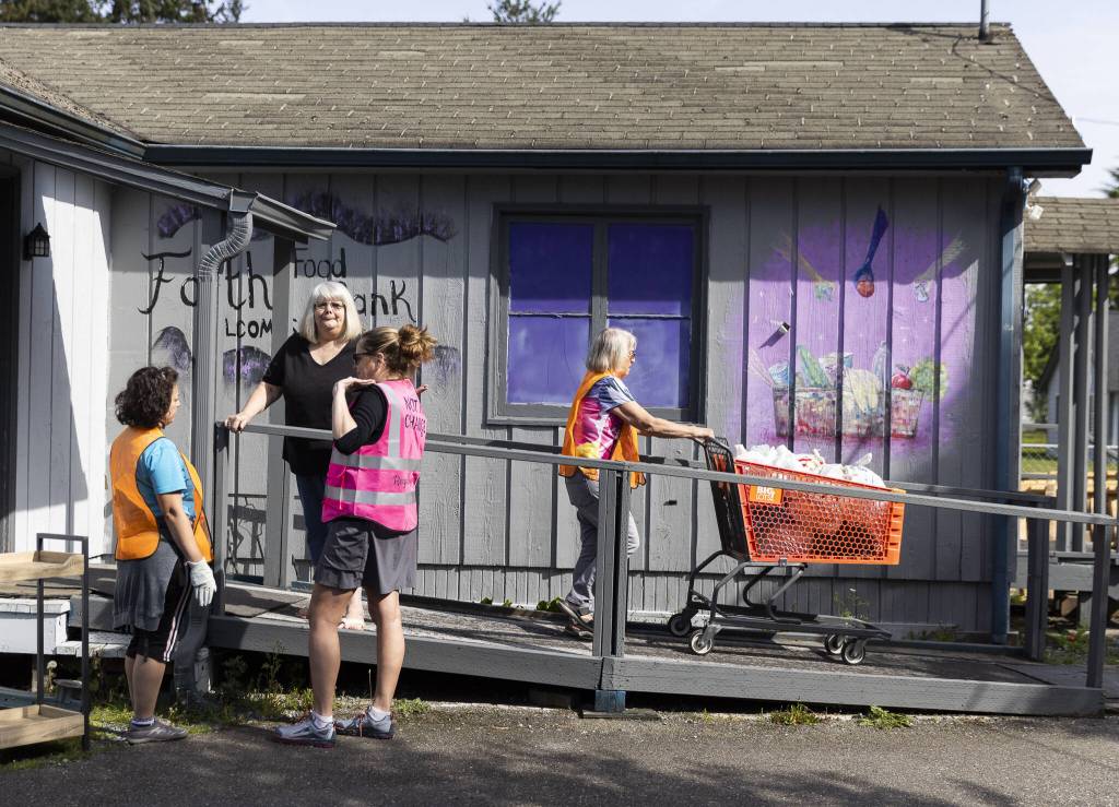 Volunteers prepare boxes for clients at the Faith Lutheran Food Bank on Friday, April 25, 2025, in Everett, Washington. (Olivia Vanni / The Herald)
