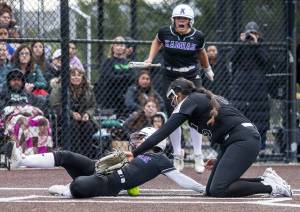 Kamiak’s Emma Stansfield slides into home to score after the ball misses the glove of Jackson’s Yanina Sherwood during the 4A district championship on Friday, May 17, 2024 in Everett, Washington. (Olivia Vanni / The Herald)