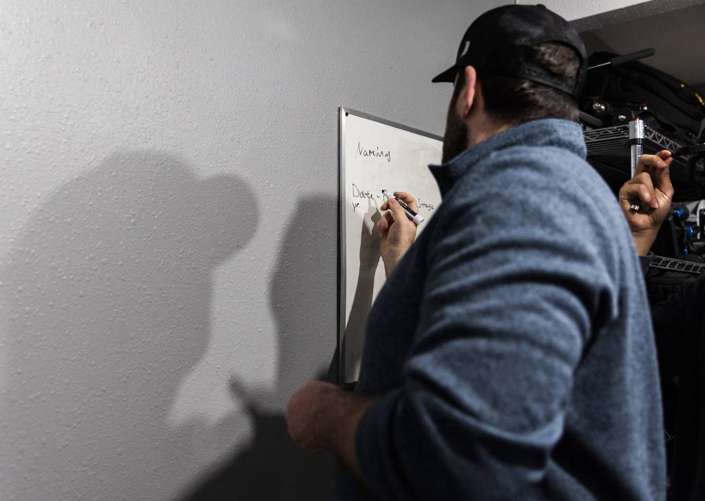 Chris Gove writes project naming instructions on a whiteboard at The Teen Storytellers Project on Tuesday, April 29, 2025 in Everett, Washington. (Olivia Vanni / The Herald)