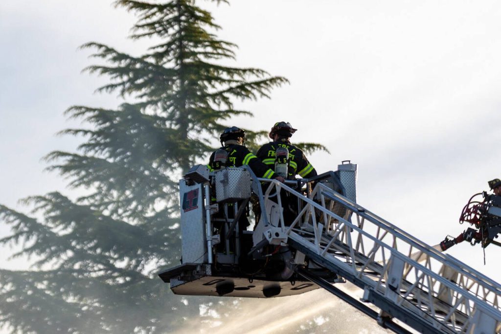 Firefighters spray water from a ladder truck onto Trojan Storage on Monday, May 5, 2025, in Everett, Washington. (Aaron Kennedy / The Herald)