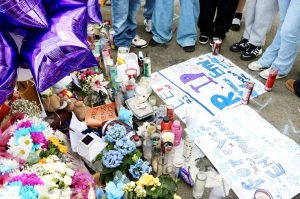 Students from Explorer Middle School gather Wednesday around a makeshift memorial for Emiliano Emi Munoz, who died Monday, May 5, after an electric bicycle accident in south Everett. (Aspen Anderson / The Herald)