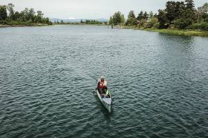 Kyle Parker paddles his canoe along the Snohomish River next to Langus Riverfront Park on Thursday, May 8, 2025 in Everett, Washington. (Olivia Vanni / The Herald)