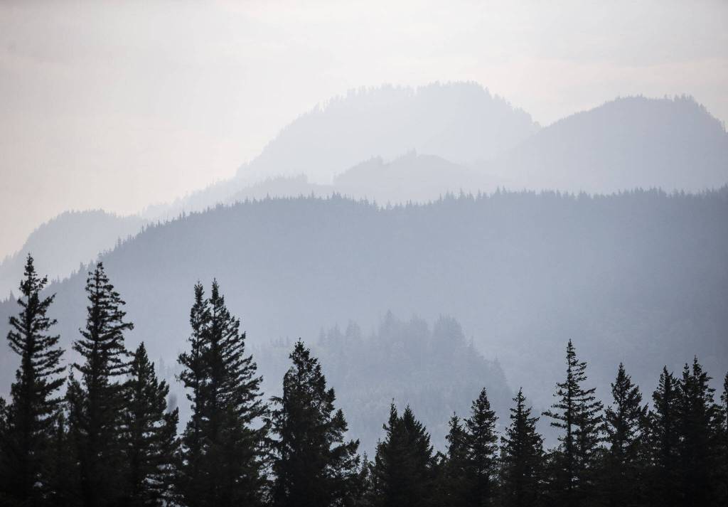 Smoke from the Bolt Creek fire silhouettes a mountain ridge and trees just outside of Index on Sept. 12, 2022. (Olivia Vanni / The Herald)
