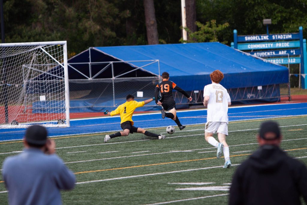 Monroes Benji Vodegel slips by Marysville Getchell keeper Laith Al-Bahathly for a late goal during a District 1 boys soccer playoff game on May 13, 2025 at Shoreline Stadium. (Qasim Ali / The Herald)