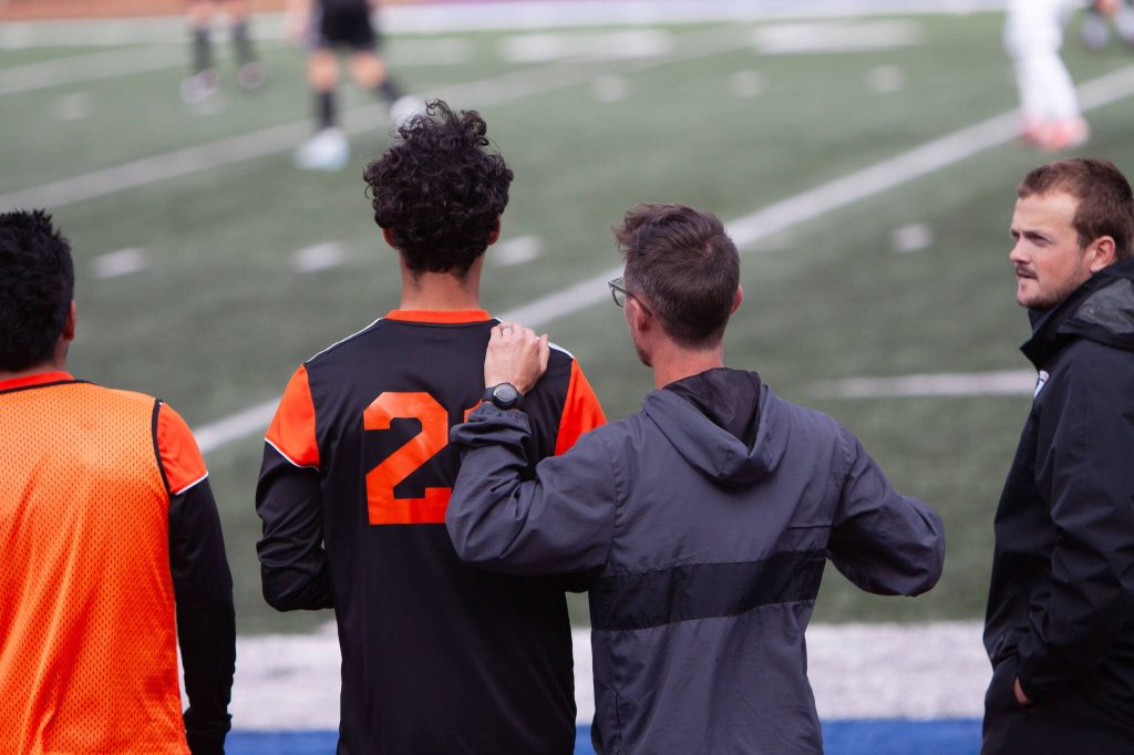 Monroe head coach Korey Hope gives defender Teygan Thomas some advice before he checks into a District 1 boys soccer playoff game against Marysville Getchell on May 13, 2025 at Shoreline Stadium. (Qasim Ali / The Herald)