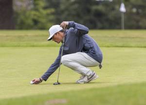 Snohomish’s Tully VanAssche places his ball on the green to putt during the 3A District 1 Boys Golf Championship at Legion Memorial Golf Course on Tuesday, May 13, 2025 in Everett, Washington. (Olivia Vanni / The Herald)