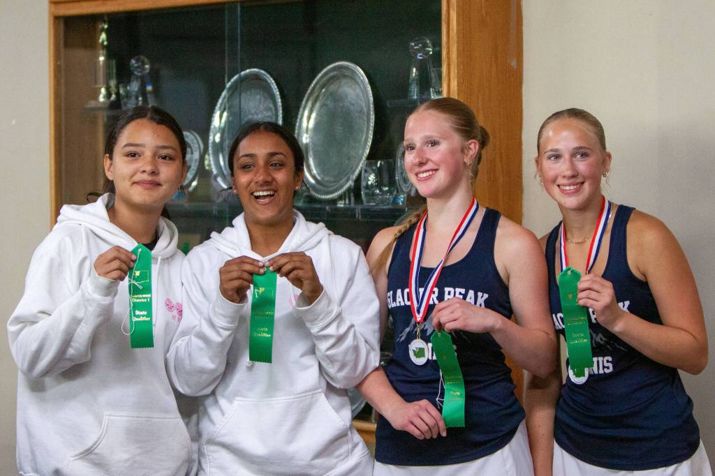(From left to right) Mariners Francys Montilla and Aarti Saran and Glacier Peaks Alyssa and Sarah Box pose for a photo after their District 1 4A doubles championship match on May 14, 2025 at Mill Creek Tennis Club. (Qasim Ali / The Herald)