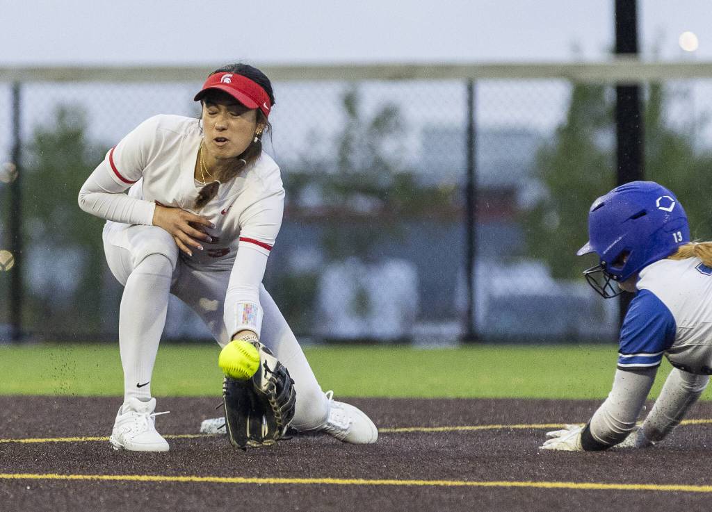 Stanwoods Rubi Lopez reacts out to stop a bouncing ball as a Sedro-Woolley plater slides into second base during the 3A District 1 championship game on Thursday, May 15, 2025 in Everett, Washington. (Olivia Vanni / The Herald)