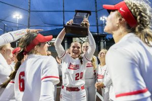 Stanwood players cheer as pitcher Addi Anderson lifts the 3A District 1 Championship trophy in the air after beating Sedro-Woolley for the title on Thursday, May 15, 2025 in Everett, Washington. (Olivia Vanni / The Herald)