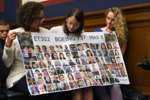 Women hold a banner with pictures of victims of one of the Boeing Max 8 crashes at a hearing where Captain Chesley B. Sully Sullenberger III testified at the Rayburn House Building on June 19, 2019, in Washington, D.C. (Katherine Frey/The Washington Post)