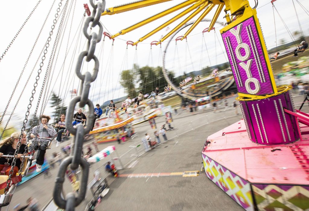 People laugh as they ride the Yoyo swings at the carnival during the opening day of the Evergreen State Fair on Thursday, Aug. 22, 2024 in Monroe, Washington. (Olivia Vanni / The Herald)