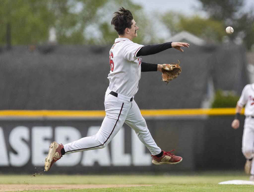 Snohomishs Reve LeRoux leaps in the air while making a throw to first base during the opening round 3A state game against Bellevue on Tuesday, May 20, 2025 in Snohomish, Washington. (Olivia Vanni / The Herald)