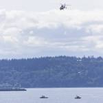 A ferry passes by as Everett Fire Department, Everett Police and the U.S. Coast Guard conduct a water rescue for a sinking boat in Possession Sound off of Howarth Park on Wednesday, May 21, 2025 in Everett, Washington. (Olivia Vanni / The Herald)