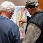 Pat Cronin and Jamie Lyon look over a zoning district map draft of Everett on display during an Everett Planning Department open house at Everett Station on Wednesday, Feb. 26, 2025 in Everett, Washington. (Olivia Vanni / The Herald)
