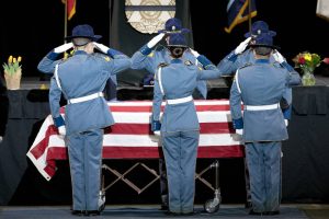 Members of Washington State patrol salute the casket of slain trooper Chris Gadd during a memorial cremony on Tuesday, March 12, 2024, at Angel of the Winds Arena in Everett, Washington. (Ryan Berry / The Herald)