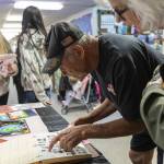 Brian Murril, who started at Liberty Elementary as a kindergartner in 1963, looks for his yearbook photograph during an open house for the public to walk through the school before its closing on Thursday, May 29, 2025 in Marysville, Washington. (Olivia Vanni / The Herald)