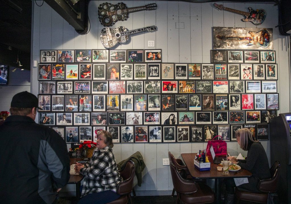 Band photos cover a wall inside the Madison Avenue Pub. (Olivia Vanni / The Herald)