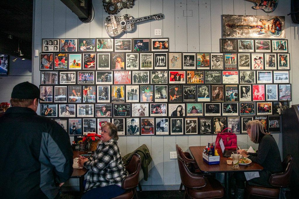 Band photos cover a wall inside the Madison Avenue Pub on Tuesday, Dec. 17, 2024 in Everett, Washington. (Olivia Vanni / The Herald)