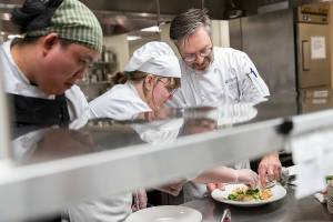 Nathan Tri, left, Natalie Lessley, center, and Chef Instructor Kevin Fogerty plate a fettuccine alfredo with saute shrimp and broccoli at the Edmonds College Cafe on Thursday, May 29, 2025 in Edmonds, Washington. (Olivia Vanni / The Herald)