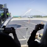 People take photos and videos as the first Frontier Arlines flight arrives at Paine Field Airport under a water cannon salute on Monday, June 2, 2025 in Everett, Washington. (Olivia Vanni / The Herald)