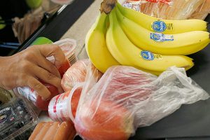 An employee bags groceries for a customer at a checkout counter inside a grocery store in 2017. (Bloomberg photo by Luke Sharrett)