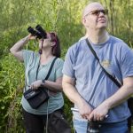 Brenda Bancroft uses binoculars to look for wildlife at the North Creek Wetlands on Wednesday, June 4, 2025 in Bothell, Washington. (Olivia Vanni / The Herald)