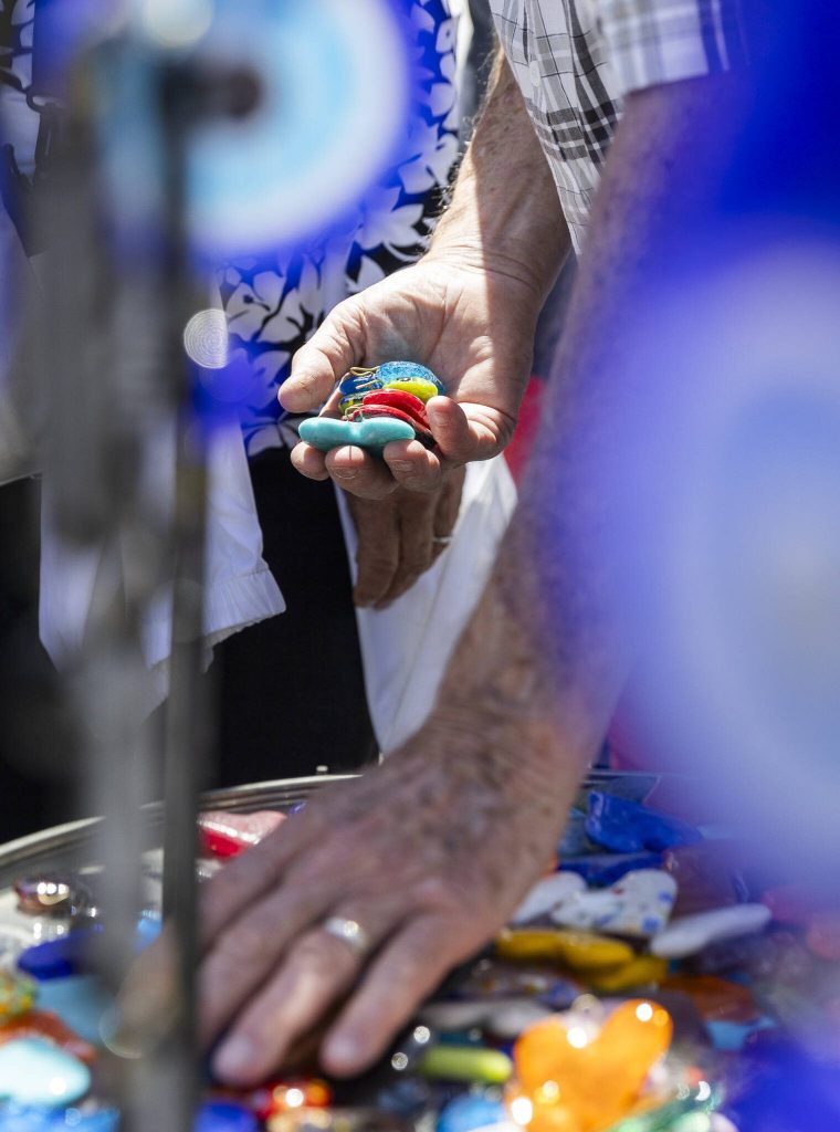 People sort through colorful glass hearts during Sorticulture on Friday, June 6, 2025 in Everett, Washington. (Olivia Vanni / The Herald)