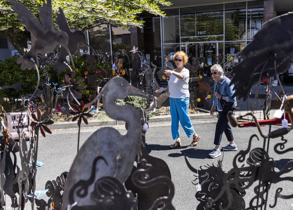 People look at a selection of metalwork creatures during Sorticulture on Friday, June 6, 2025 in Everett, Washington. (Olivia Vanni / The Herald)