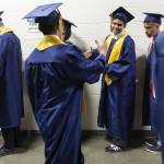 Graduates greet each other as they line up during Mariner High Schools 2025 commencement on Friday, June 13, 2025, at Angel of the Winds Arena in Everett, Washington. (Olivia Vanni / The Herald)