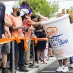 Candie Tallquist high-fives people dressed as a Dicks Drive-In milkshake on Thursday, June 12, 2025 in Everett, Washington. (Olivia Vanni / The Herald)