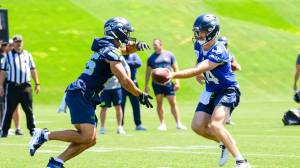 Seahawks quarterback Sam Darnold (14) hands off to running back Zach Charbonnet (26) during minicamp at the Virginia Mason Athletic Center on Tuesday, June 10, 2025. (Photo courtesy of Edwin Hooper, Seattle Seahawks)