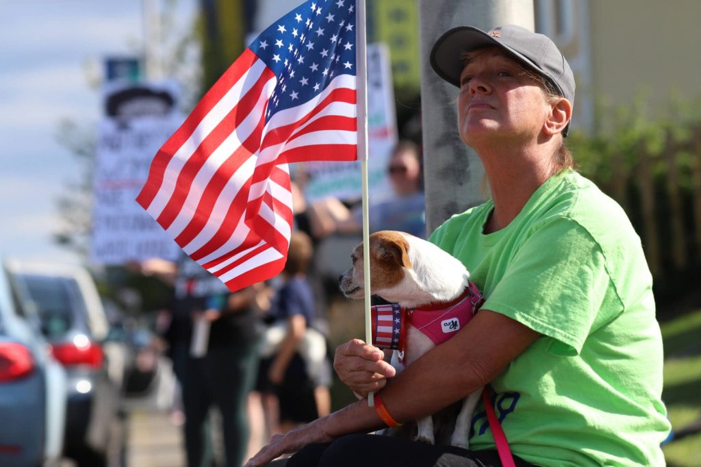 Kari Skorstad holds Rebel, her 4-year-old Chihuahua, on her lap during a No Kings Day rally along Broadway on Saturday, June 14, 2025, in Everett, Washington. (Mike Henneke / The Herald)