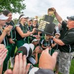 Jackson High School's Kyle Peacocke hands the 2023 WIAA class 4A softball championship trophy to the team after their win in Richland, Wash., on Sat., May 27, 2023. (TJ Mullinax / for The Herald)