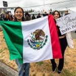 A group of Cascade High School students held signs and flags while protesting along Evergreen Way on Friday, June 20, 2025 in Everett, Washington. (Aaron Kennedy / The Herald)