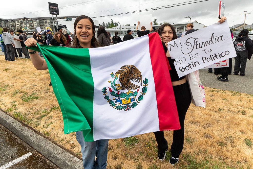 A group of Cascade High School students held signs and flags while protesting along Evergreen Way on Friday in Everett. (Aaron Kennedy / The Herald)